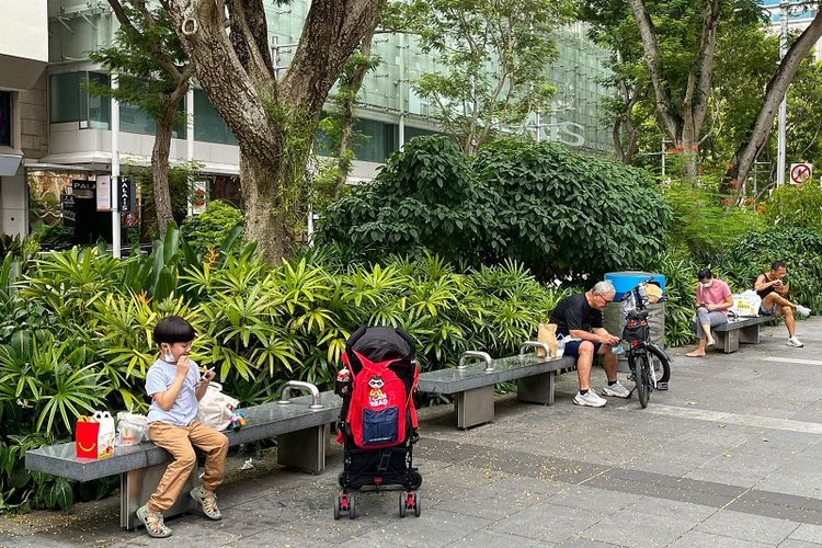 Warga Singapura terlihat menyantap makan siang mereka di bangku-bangku Orchard Road, Sabtu siang (7/8/2021). Sesuai dengan peraturan lockdown parsial yang sedang diterapkan di Singapura, pusat-pusat makanan seperti restoran, food court, kedai kopi, dan hawker diizinkan beroperasi hanya untuk take away atau membawa pulang makanan hingga 9 Agustus