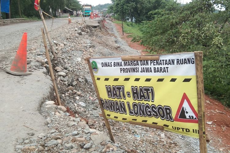 Kendaraan melintas di Jalan Badami-Loji, Kampung Nyangkokot, Desa Wanasari, Kecamatan Telukjambe Barat, Kabupaten Karawang, yang longsor sejak setahun terakhir, Senin (17/1/2022).