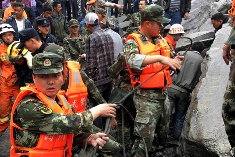 Lebih dari 140 orang tertimbun longsor di Sichuan, China, Sabtu (24/6/2017). Tampak regu penelamat berusaha keras memindahkan bongkahan batu untuk menemukan para korban.