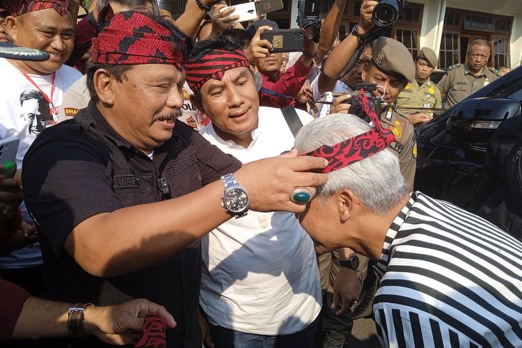 Caption: Bupati Nganjuk Marhaen Djumadi mengenakan Udeng Anjuk Ladang ke Ganjar Pranowo di Pendopo KRT Sosrokoesoemo Pemkab Nganjuk, Jumat (23/6/2023)