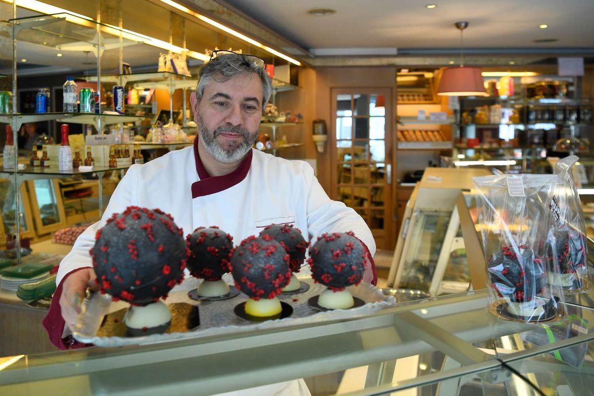 Chocolatier Jean-Francois Pre menyiapkan telur paskah berbentuk seperti virus corona di tokonya di Landivisiau, Barat Perancis, 7 Maret 2020. Cokelat ini terbuat dari cokelat putih yang diberikan pewarna hitam serta dipadukan dengan kacang almond yang diwarnai merah.