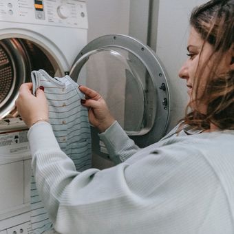 Ilustrasi mencuci pakaian dengan mesin cuci. 