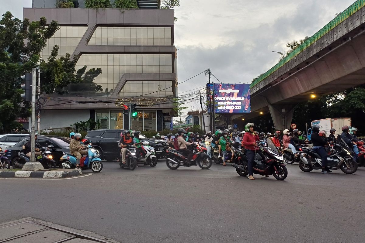 Penampakan pengendara motor yang melakukan pelanggaran lalu lintas berupa berhenti melewati zebra cross saat lampu merah di Simpang Santa, Jakarta Selatan, Jumat (8/3/2024).