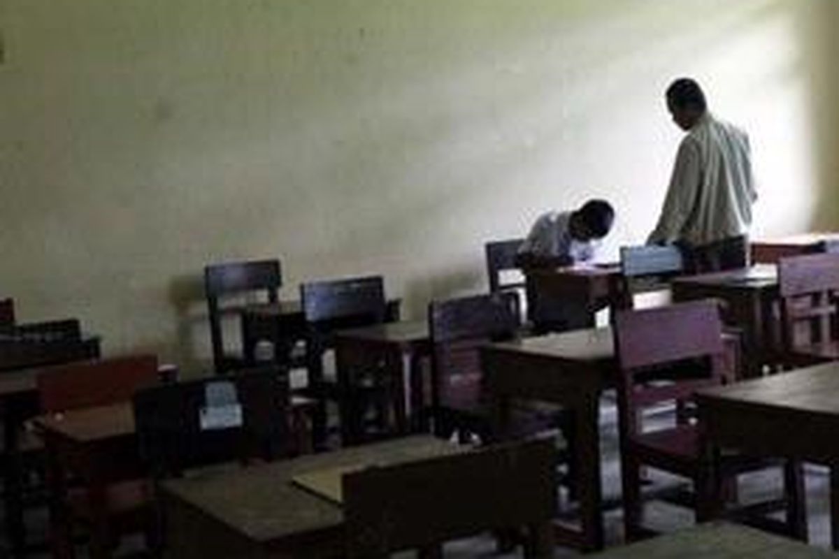 M Rafli, pengawas Ujian Nasional di SMA Negeri 2 Banjarbaru, Kalimantan Selatan, menunggu salah satu siswa peserta Ujian Nasional yang terlambat menyelesaikan soal ujian Bahasa Indonesia. Hari pertama Ujian Nasional, Selasa (22/4), di sekolah favorit di Banjarbaru ini di ikuti seluruh kelas 12 nya sebanyak 186 siswa.