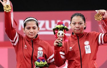 Pebulu tangkis ganda putri Indonesia Oktila Leani Ratri (kiri) dan Sadiyah Khalimatus berpose dengan medali emas saat prosesi penyerahan medali bulu tangkis nomor ganda putri kategori SL3-SU5 pada Paralimpiade Tokyo 2020 di Yoyogi National Stadium, Tokyo, Jepang, Sabtu (4/9/2021). Leani/Khalimatus meraih medali emas setelah mengalahkan wakil China Cheng He Fang-Ma Huihui dengan skor 21-18 dan 21-12.