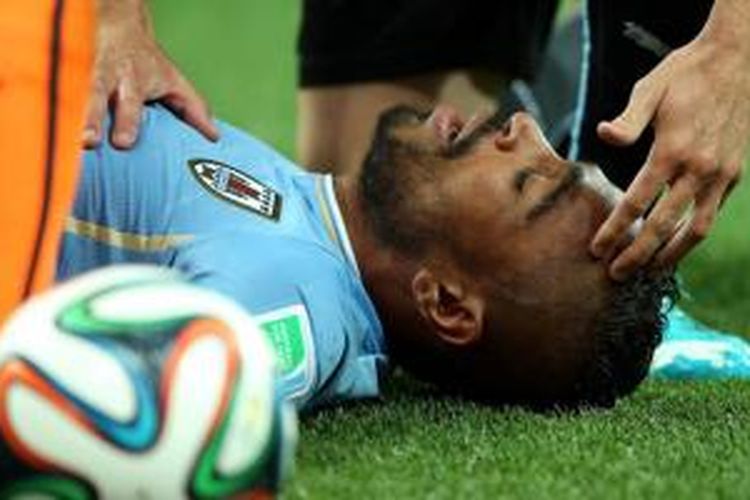 Pemain Uruguay Alvaro Pereira jatuh setelah terkena kaki pemain Inggris, pada laga Piala Dunia Brasil, Jumat (20/6/2014).