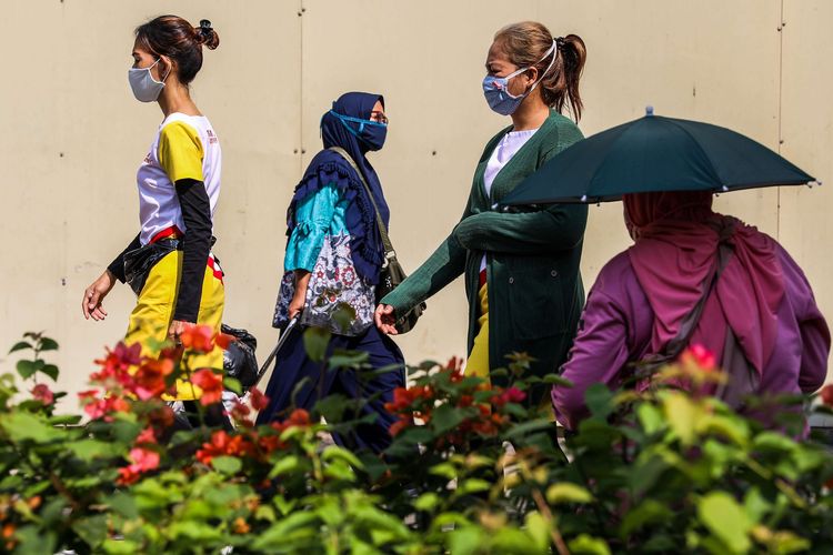 Pekerja menggunakan masker saat berjalan menuju perkantoran di Kawasan Tanah Abang, Jakarta Pusat, Senin (21/9/2020). PSBB kembali diterapkan mulai tanggal 14 September 2020, berbagai aktivitas kembali dibatasi yakni aktivitas perkantoran, usaha, transportasi, hingga fasilitas umum.