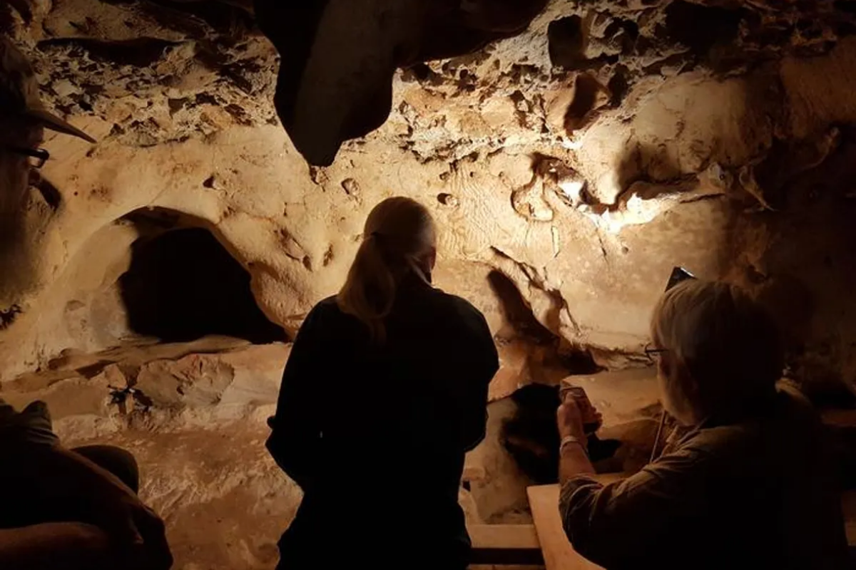 Peneliti berada di dalam gua Perancis La Roche-Cotard yang menjadi lokasi penemuan karya seni Neanderthal.
