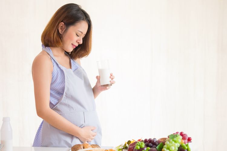 Ilustrasi ibu hamil menjaga kehamilan dengan mengonsumsi makanan dan minuman bernutrisi. 