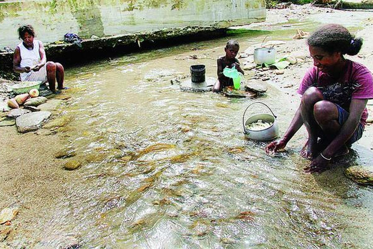 Korban banjir bandang di Wasior, Teluk Wondama, Papua Barat, Magdalena Karubuy (kiri) dan Paulina Sayori, mengupas jantung pohon pisang dan batang bambu untuk dibuat sayuran, Minggu (7/11). Bantuan makanan sudah tidak mereka terima lagi. Penduduk bertahan hidup dengan bahan makanan dari hutan.