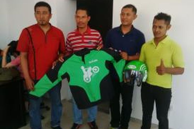 Mantan pemain timnas sepak bola Indonesia Anang Ma'ruf (kedua dari kiri) menerima atribut Go-Jek setelah resmi bergabung dengan perusahaan aplikasi pemesan layanan ojek itu, Jumat (4/9/2015).