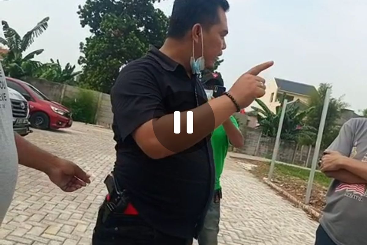 Tangkapan layar sebuah video yang memperlihatkan seorang pria adu mulut dengan sejumlah orang sambil menyelipkan pistol di celananya, tepatnya di bagian pinggang, pada Kamis (22/7/2021). Saat video diambil, SI tengah terlibat cekcok dengan warga di Apartemen City Garden, Cengkareng, Jakarta Barat.