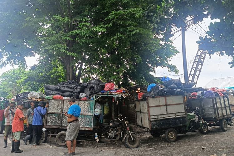 Petugas pengangkut sampah menunggu antrean di TPS Yang Batu, Denpasar, Jumat (12/12/2025) sore. 