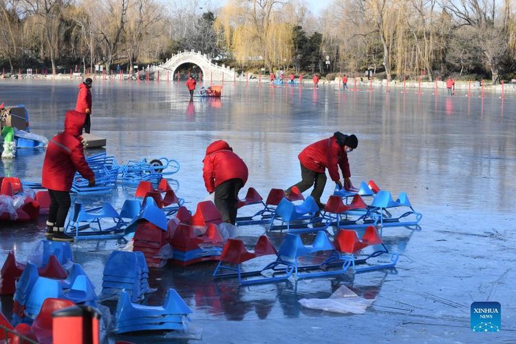 Anggota staf menyiapkan kereta luncur di danau beku di Taman Yuanmingyuan di Beijing, China, (30/12/2021). Istana Musim Panas Lama, atau Yuanmingyuan, mengumumkan pada hari Kamis bahwa mereka akan mengadakan festival es dan salju yang dibuka sekitar hari Tahun Baru pada tahun 2022 dan berlangsung hingga Februari untuk menyambut Olimpiade Musim Dingin Beijing 2022. (Xinhua/Luo Xiaoguang)