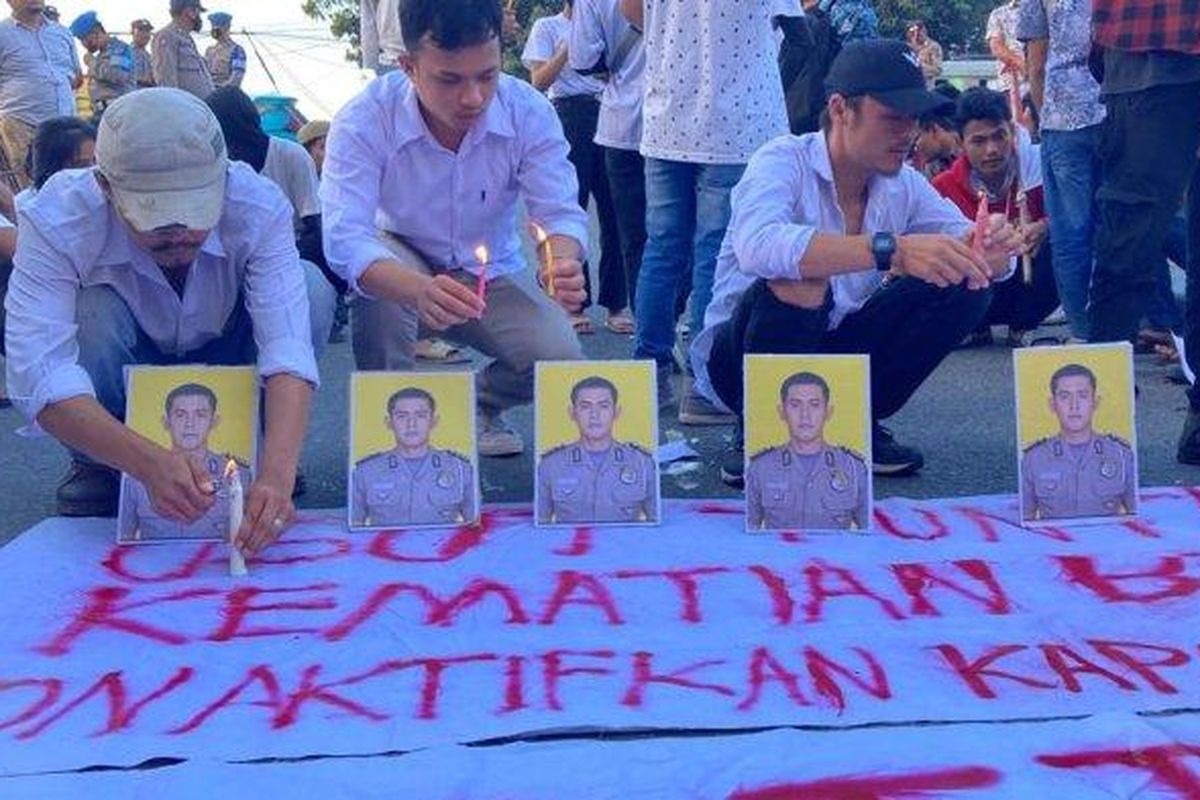 Mahasiswa dari perhimpunan mahasiswa Kabupaten Samosir berunjuk rasa di depan pintu masuk Mapolda Sumut, Rabu (29/3/2023) sore. 
Mereka menyalakan lilin di depan foto almarhum Bripka Arfan Saragih (AS) dan mendesak Polda Sumut mengungkap kasus ini secara transparan 

