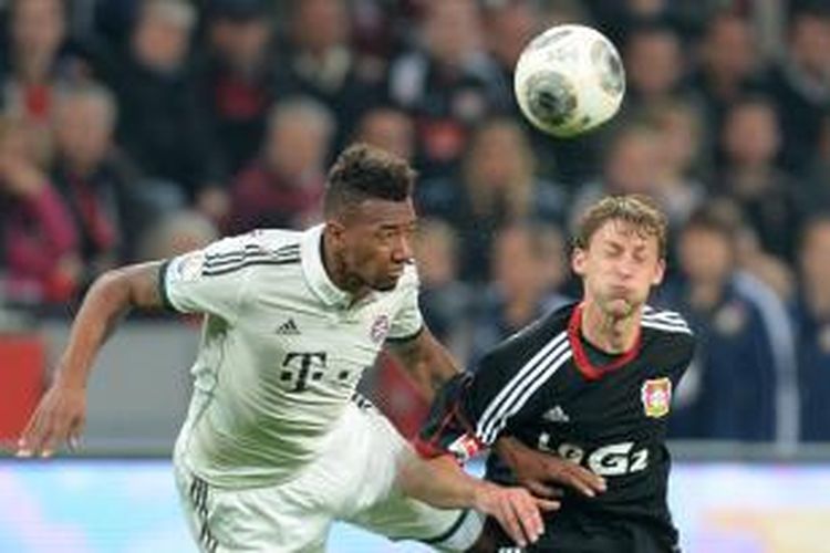 Striker Bayer Leverkusen, Stefan Kiessling (kanan), berebut bola dengan bek Bayern Muenchen, Jerome Boateng, saat kedua tim bertemu di ajang Bundesliga, Sabtu (5/10/2013, yang berakhir dengan skor 1-1.