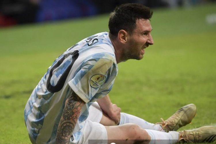 Lionel Messi duduk di lapangan seusai terkapar dalam laga timnas Argentina vs Uruguay di Copa America 2021, 18 Juni 2021.