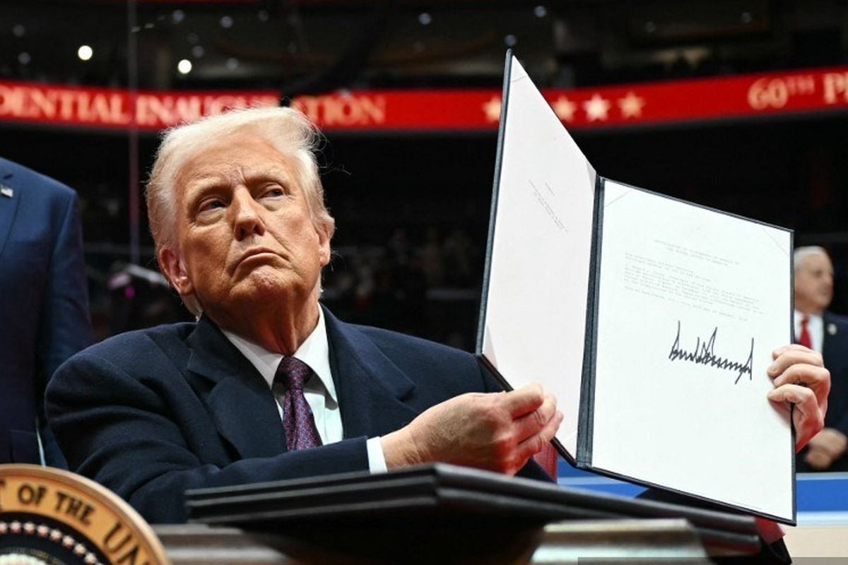 Presiden Amerika Serikat Donald Trump menunjukkan surat ke PBB yang berisi AS keluar dari Paris Agreement (perjanjian iklim), saat pelantikannya di Capital One Area, Washington DC, Senin (20/1/2025).