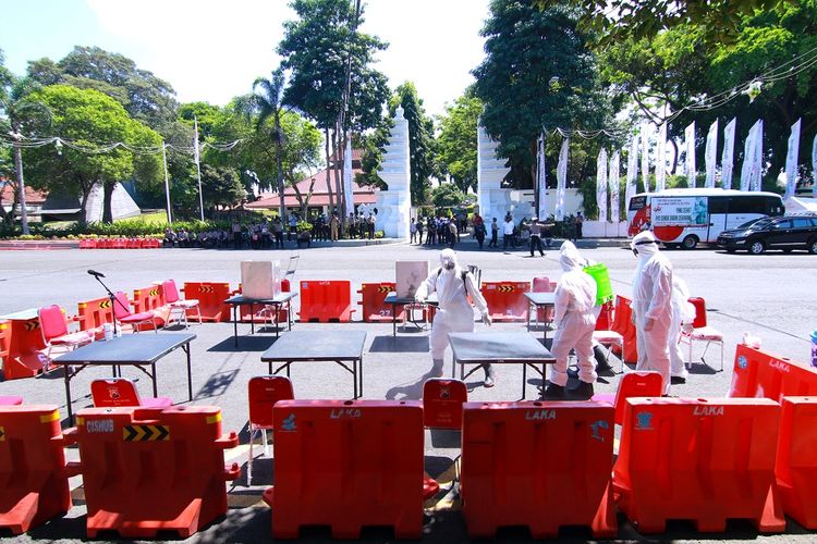 Petugas kesehatan menyemprotkan cairan disinfektan di Tempat Pemungutan Suara saat simulasi Pemilihan Kepala Daerah di Banyuwangi, Jawa Timur, Senin (14/9/2020).  Simulasi tersebut digelar untuk menyiapkan segala hal yang diperlukan untuk penyelenggaraan Pilkada serentak pada 9 Desember 2020 di tengah wabah COVID-19. ANTARA FOTO/Budi Candra Setya/wsj.