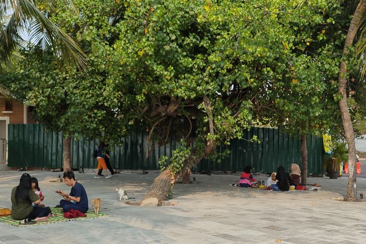 Tampak pengunjung yang berekreasi di pantai Ancol menggelar tikar dengan jarak berjauhan untuk menerapkan physical distancing atau jaga jarak selama masa pandemi, Sabtu (27/6/2020).