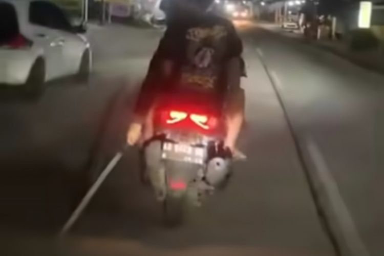 Tangkap layar Pemuda mengendarai sepeda motor membawa senjata tajam diduga pedang digesek kan di Jalan Raya, Wilayah Kabupaten Sragen, Jawa Tengah, viral di media sosial, pada Minggu (16/4/2023).