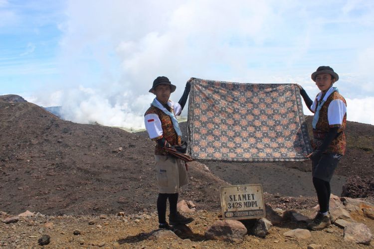 Siswanto dan Sultan sedang membentangkan kain batik di puncak Gunung Slamet pada Jumat (7/9/2018).
