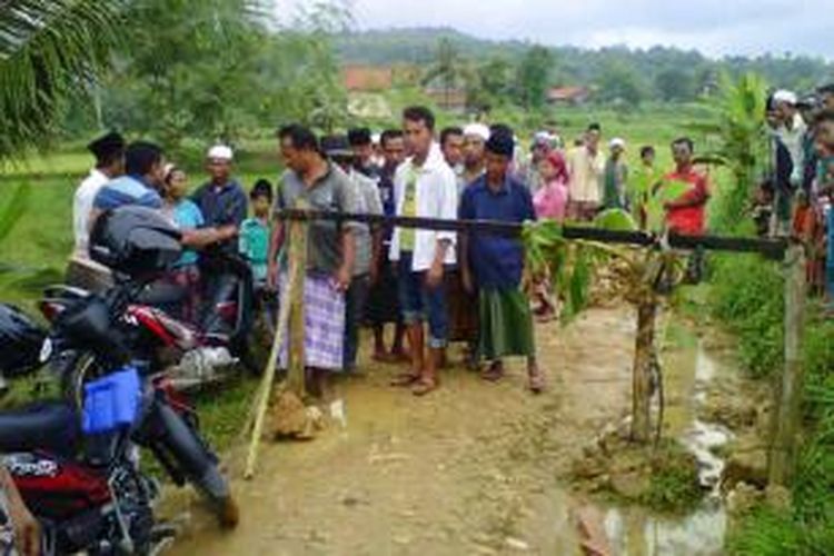 Warga Desa Pasanggher dan Palek Sanggher, Kecamatan Pegantenan, menutup jalan desa dengan menanami pohon pisang dan menggali parit agar tidak dilewati warga. 