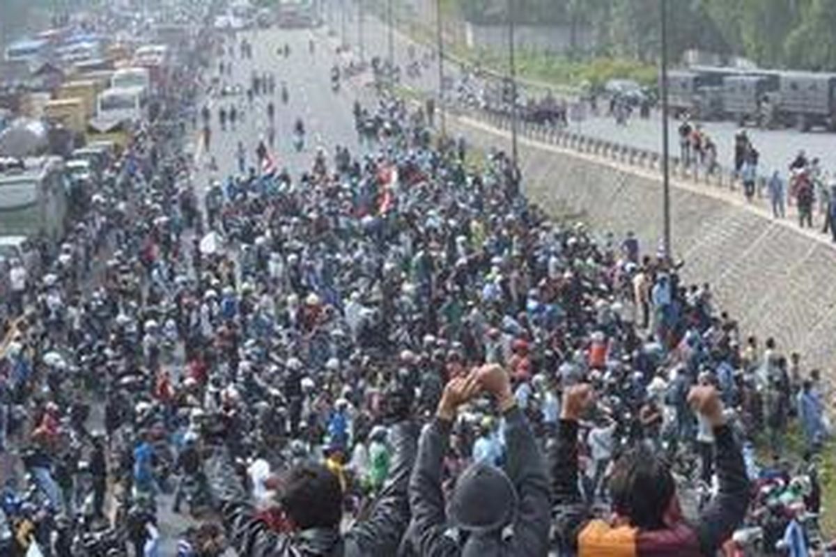 Unjuk rasa buruh dengan menutup tol Jakarta-Cikampek di sekitar pintu tol Cikarang Barat, Bekasi, Jumat (27/1/2012).