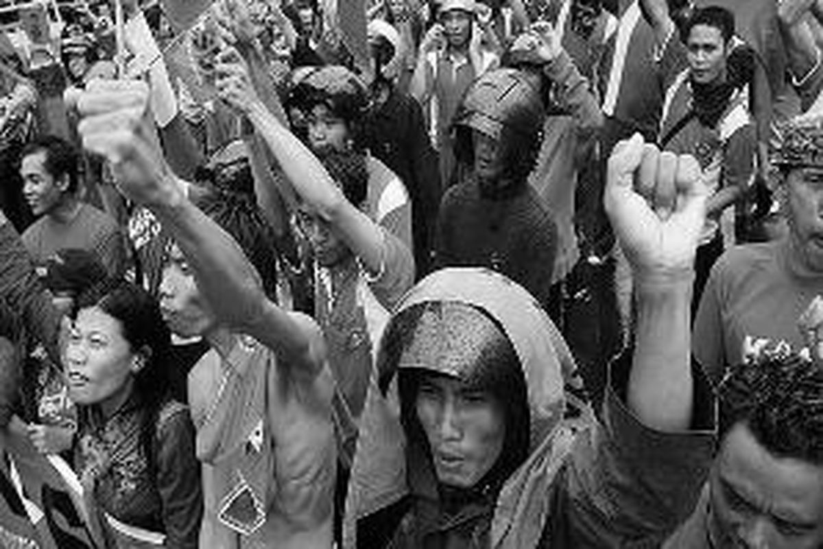 Ratusan buruh dari Surabaya dan sekitarnya berunjuk rasa di depan Kantor Gubernur Jawa Timur di Jalan Pahlawan, Surabaya, Rabu (19/11). Mereka menolak Peraturan Bersama Empat Menteri tentang upah minimum kabupaten/kota (UMK) dan meminta agar Pemprov Jatim menetapkan UMK sebesar Rp 964.010. 