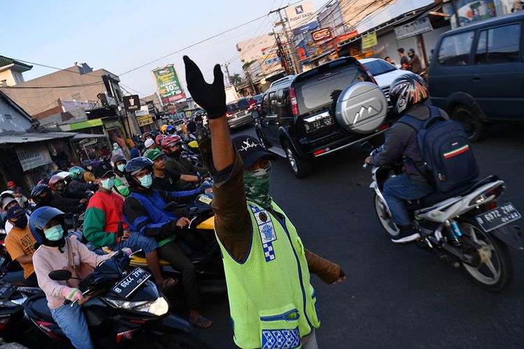 Warga membantu mengatur lalu lintas kendaraan di Jalan Raya Sawangan, Depok, Jawa Barat, Sabtu (16/5/2020). Meski penerapan Pembatasan Sosial Berskala Besar (PSBB) Kota Depok masih diperpanjang hingga 26 Mei 2020, namun sejumlah ruas jalan mulai ramai dipadati kendaraan hingga menyebabkan kemacetan.