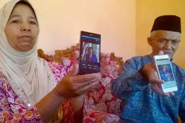 Kedua orangtua Ima Matul Maisaroh, yakni Turiyo (kanan) dan Alima, tengah menunjukkan foto anaknya yang ada di telepon selular, di rumahnya di Dusun Krajaan, Kanigoro, Kecamatan Pagelaran, Kabupaten Malang, Jawa Timur, Senin (25/7/2016).