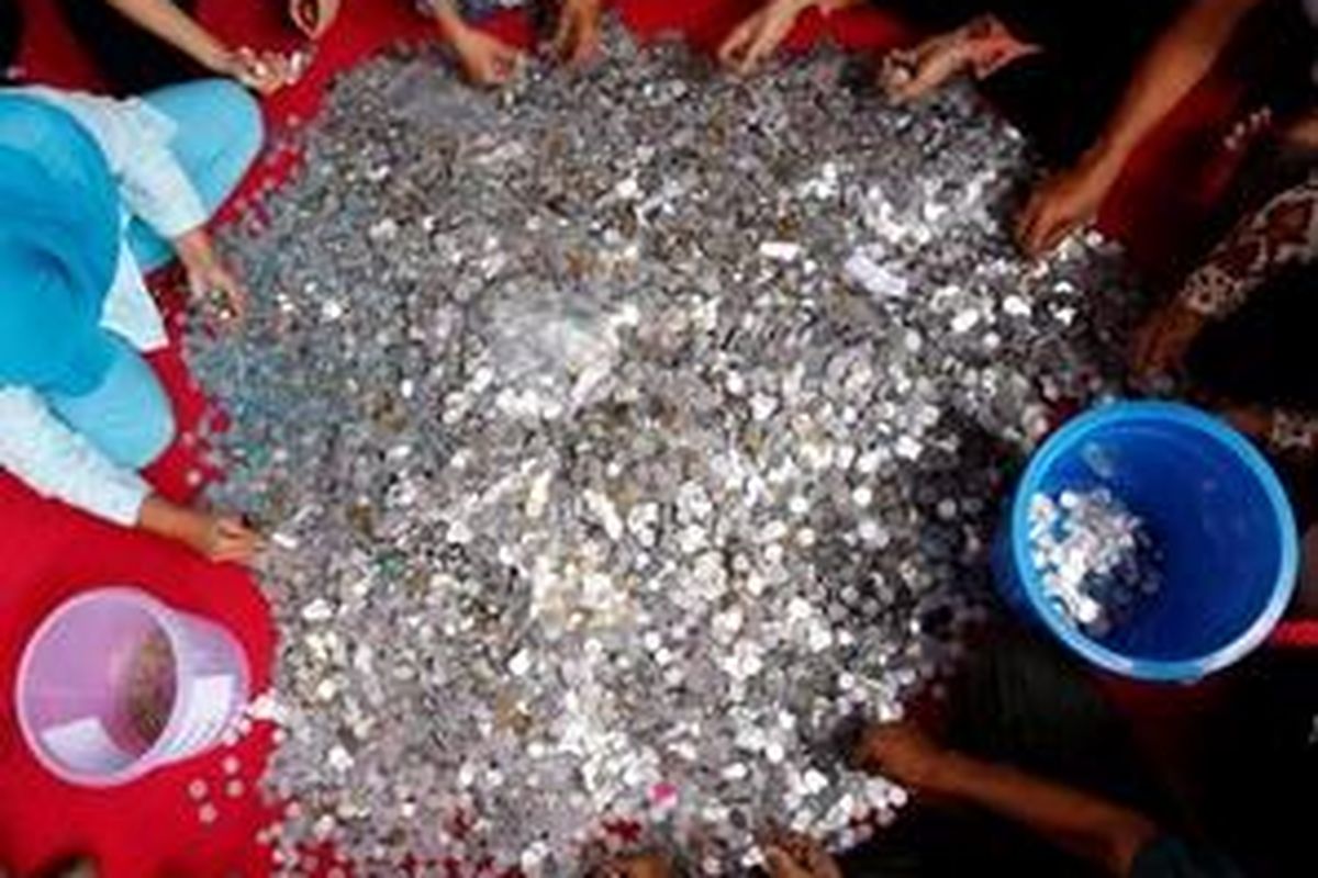 Sejumlah relawan menghitung uang koin hasil aksi Pengumpulan Koin untuk Keadilan Prita di Posko Wetiga, Kramat Pela, Jakarta Selatan, Senin (14/12/2009). Koin yang telah terhitung tersebut akan diserahkan kepada Prita meskipun RS. Omni telah mencabut seluruh gugatan perkara termasuk tuntutan ganti rugi sebesar Rp 204 juta. 