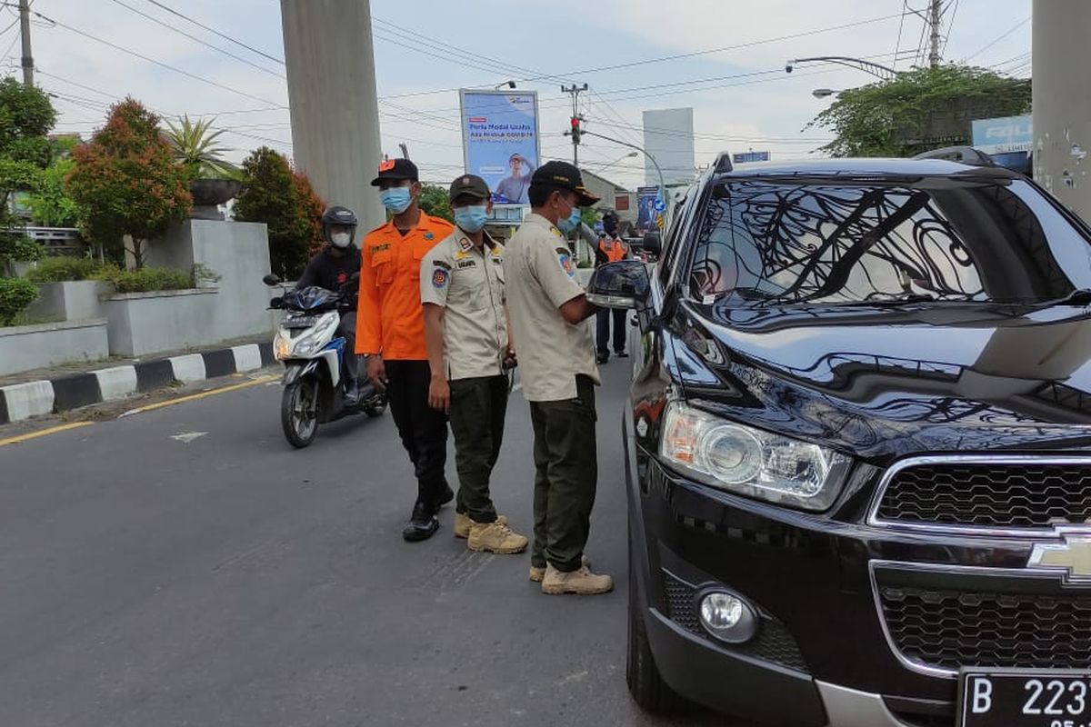 Petugas memeriksa kelengkapan dokumen kendaraan sebelum masuk ke kota Solo, Jawa Tengah