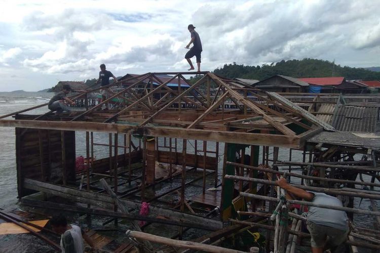 Warga bersama BPBD memperbaiki satu rumah yang rusak dan jatuh ke laut akibat angin puting beliung yang melanda sejumlah desa di enam Kecamatan di Kabupaten Tapanuli Tengah, Rabu (31/3/2021). Sedikitnya 15 rumah dikabarkan rusak dan satu diantaranya hanyut jatuh ke laut.