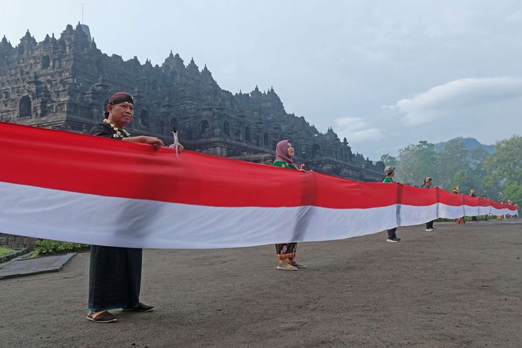 Peserta membentangkan bendera merah putih mengelilingi Candi Borobudur saat peringatan Hari Lahir Pancasila di Taman Wisata Candi (TWC) Borobudur, Magelang, Jawa Tengah, Rabu (1/6/2022). Kegiatan pembentangan bendera sepanjang satu kilometer yang diikuti oleh berbagai elemen masyarakat tersebut sebagai wujud semangat persatuan dan kesatuan bangsa dalam menjaga dasar negara Pancasila.