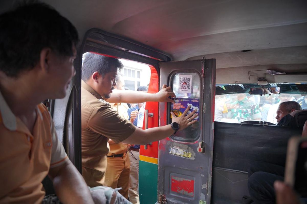 Wali Kota Medan Bobby Nasution menempelkan secara simbolis stiker tanda subsidi pada kendaraan angkutan umum di Jalan Pulau Pinang Medan, Senin (3/10/2022).