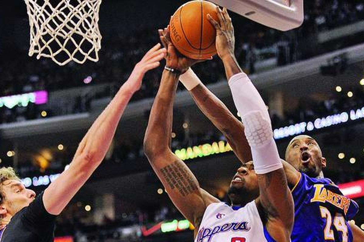 Pemain LA Clippers, DeAndre Jordan (putih), yang berusaha melakukan dunk, diganggu dua pemain LA Lakers, Pau Gasol (kiri) dan Kobe Bryant. Pada laga melawan tim satu kota di Staples Center ini, Clippers menang 102-94 atas Lakers.