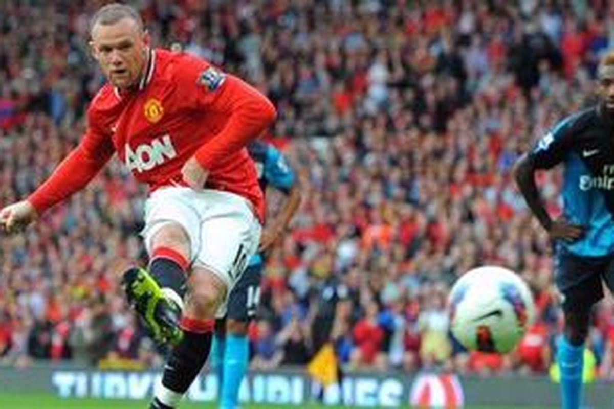 Penyerang Manchester United, Wayne Rooney, melakukan eksekusi penalti, yang berujung gol ke gawang Arsenal, pada pertandingan Premier League, di Old Trafford, Minggu (28/8/2011).