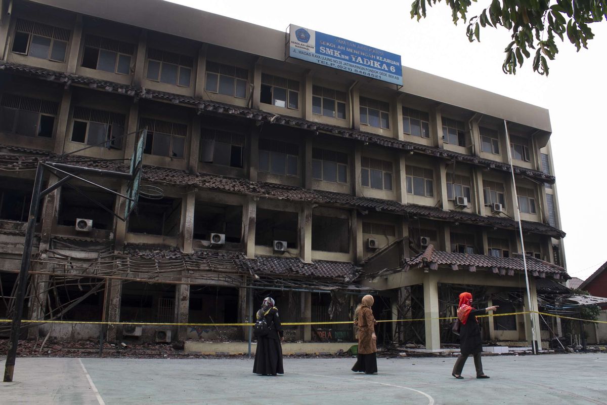 Tenaga pengajar SMK Yayasan Abdi Karya (YADIKA) 6 mengecek kondisi bangunan pasca terbakar senin lalu, Pondok Gede, Jaticempaka, Bekasi, Rabu (20/11/2019). Atas kejadian tersebut untuk sementara waktu kegiatan sekolah diliburkan.