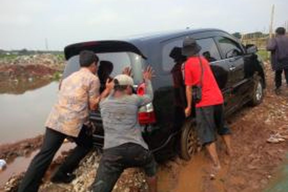 Kendaraan dinas Gubernur Jakarta Joko Widodo, Innova B1124BH terjebak dalam lumpur di Taman BMW, Tanjung Priok, Jakarta Utara, kamis (13/3/2014).