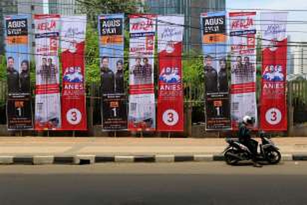 Pengendara sepeda motor melaju di samping baliho bergambar tiga pasangan calon Gubernur dan Wakil Gubernur DKI Jakarta di Jalan Kuningan, Jakarta, Rabu (23/11/2016). KPU DKI Jakarta menyediakan alat peraga kampanye untuk setiap pasangan calon dengan jumlah yang sama, namun apabila masih dirasa kurang mencukupi, masing-masing pasangan calon dibebaskan menambah alat peraga maksimal sebanyak 150 persen dari yang diadakan KPU.