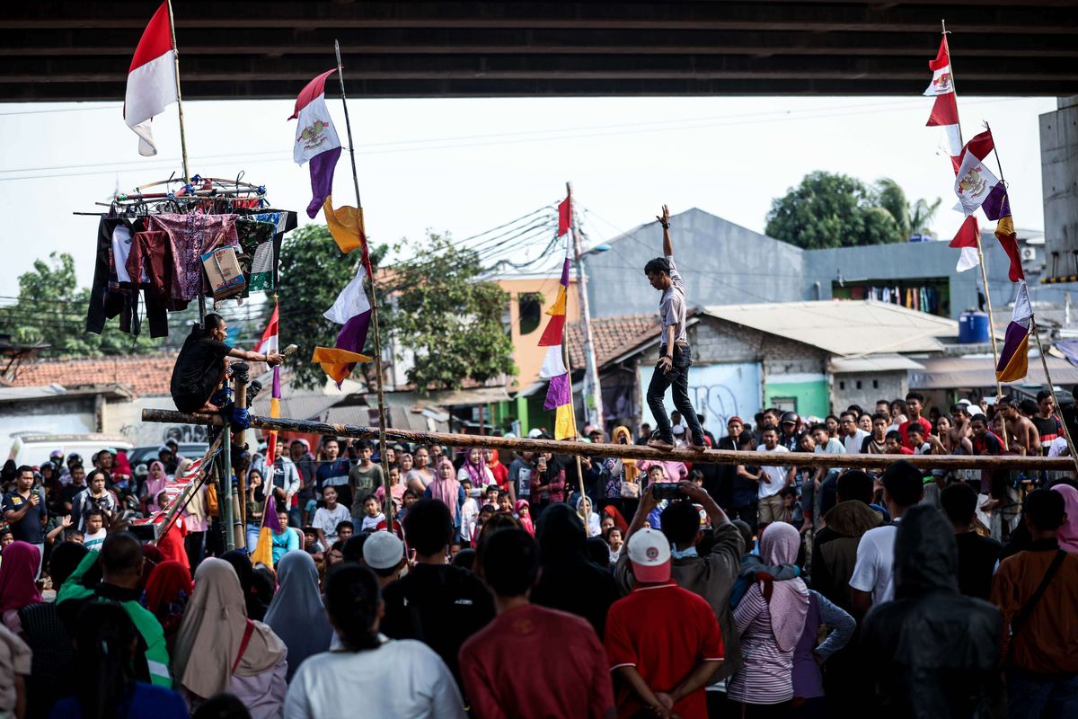 Warga mengikuti lomba panjat pinang, pukul bantal dan makan donat untuk memeriahkan HUT ke-74 Kemerdekaan RI di saluran Kalimalang, Jakarta Timur, Sabtu (17/8/2019).