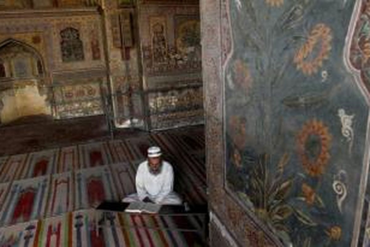 Muslim Pakistan membaca Alquran di Masjid  Wazir Khan, salah satu masjid  bersejarah di Lahore, Pakistan, 10 Juli 2013.
