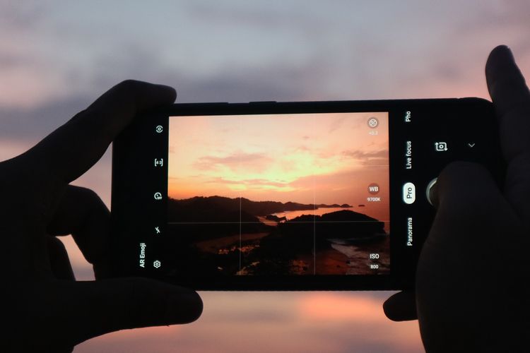 Seorang wisatawan mengabadikan sunrise dengan gawainya di Puncak Bukit Kasap, Pacitan, Jawa Timur, Rabu (29/1/2020).