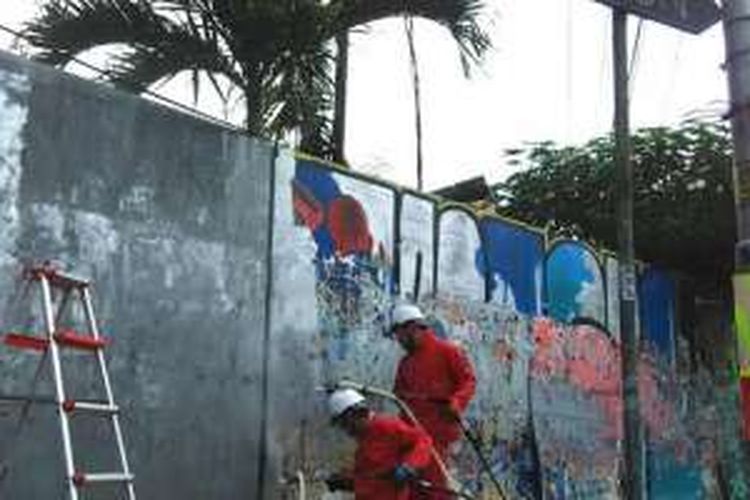 Warga negara Jepang dengan memakai wearpack berwarna merah membersihkan aksi vandalisme yang merusak keindahan kota Yogyakarta, Selasa (25/10/2016). 