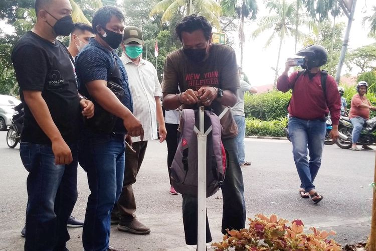 Foto: Polisi melakukan rekonstruksi kasus tas 'Awas Ada Bom'. Terduga pelaku inisial RR (45) memperagakan dirinya saat meletakkan tas tersebut, di simpang Jalan MH dan Jalan Gunung Simanuk manuk, Kecamatan Siantar Barat, Selasa (31/8/2021).