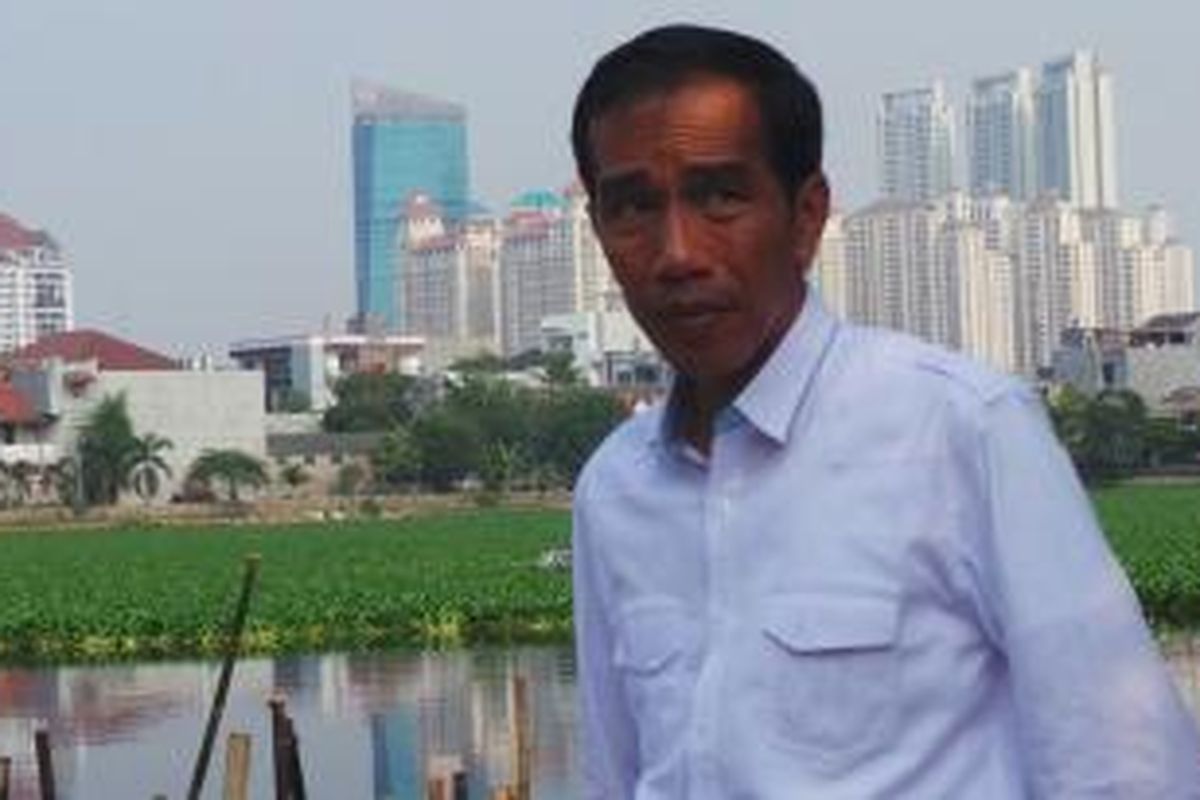 Gubernur DKI Jakarta Joko Widodo meninjau Waduk Tomang Barat, Grogol, Jakarta Barat, Jumat (27/9/2013). Tampak di belakang Jokowi hamparan tanaman eceng gondok menutupi permukaan waduk. Waduk tersebut akan dinormalisasi mulai November.