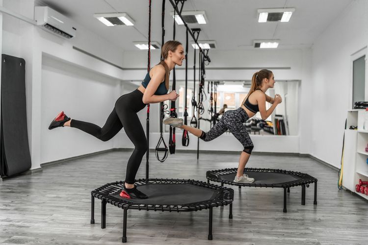 Portrait of a group two girls in gymnastics fitness trampolines in the gym, girls train make stretching body flexibility smile and good mood.