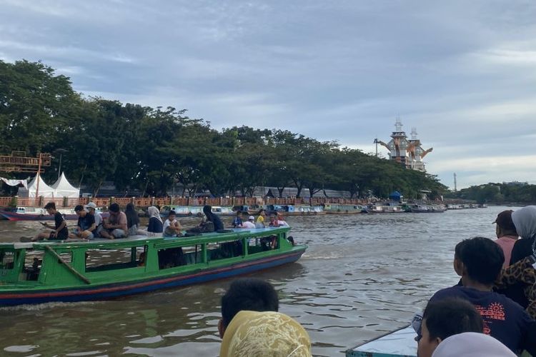 Para wisatawan menumpang perahu kelotok sambil menunggu waktu berbuka puasa di Sungai Martapura, Kota Banjarmasin, Selasa (28/3/2023).