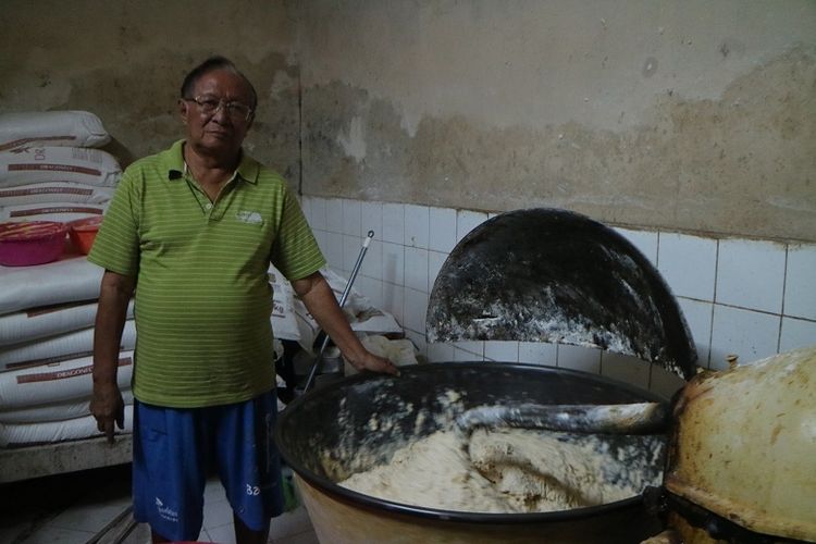 Mulyana pewaris Toko Roti Tan Keng Chu berdiri di samping mesin penggiling yang sudah berusia hampir 100 tahun.